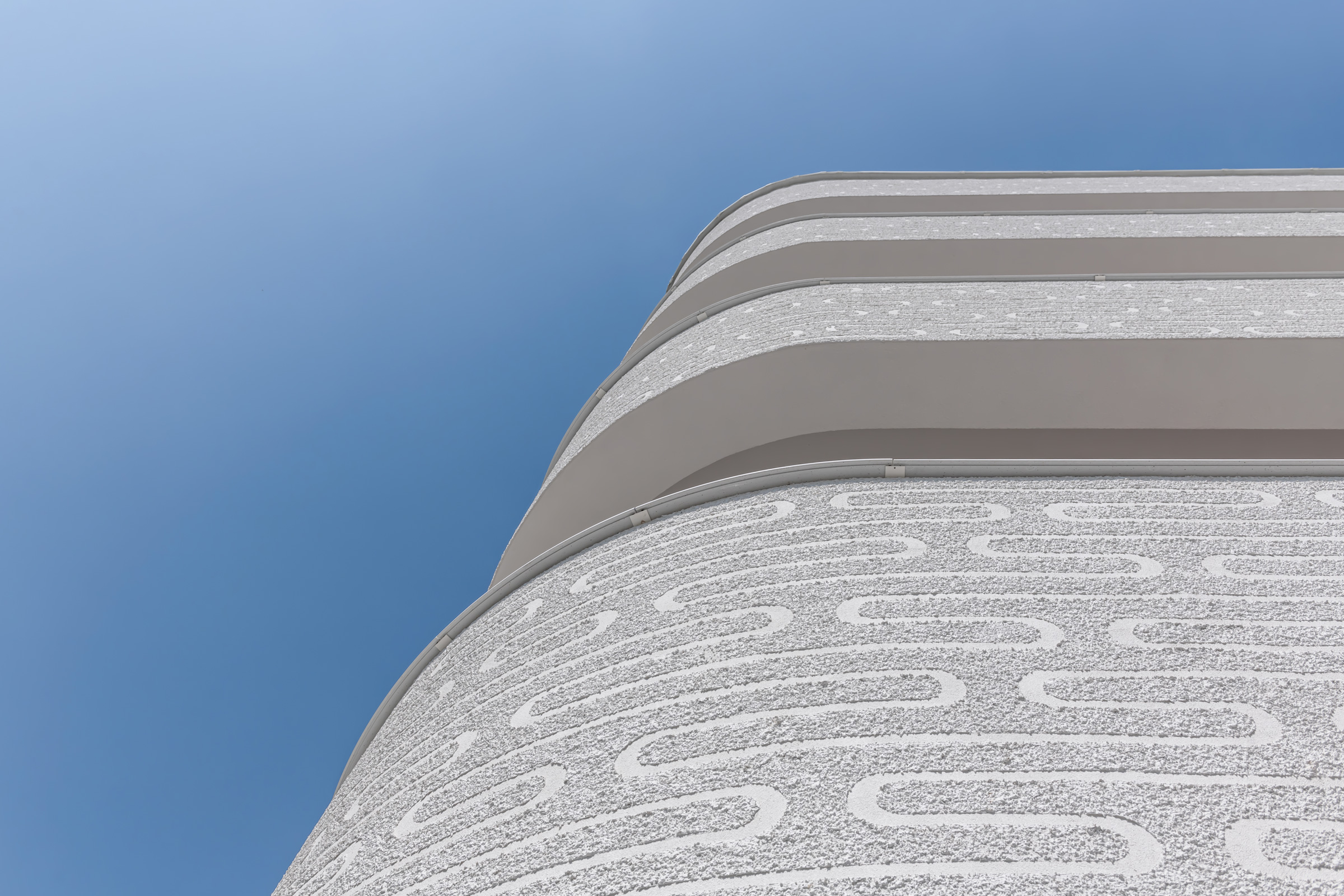 Architektonický návrh domova pre seniorov s oblými balkónmi a ornamentálnou fasádou.