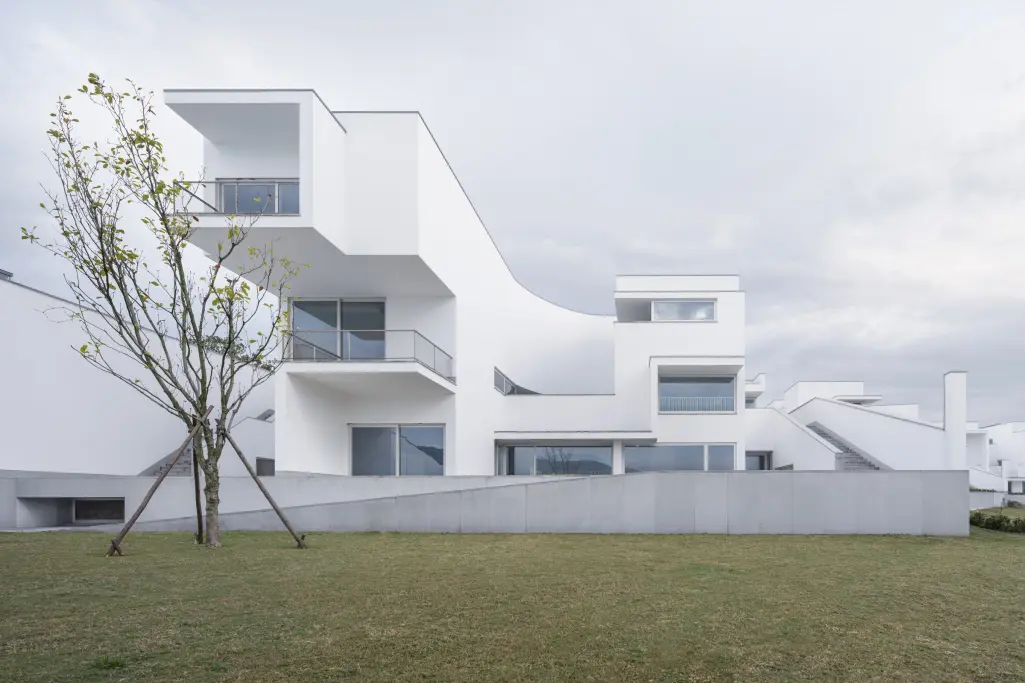 Biele omietnuté povrchy zvýrazňujú geometriu stavieb a ich čistý architektonický výraz.